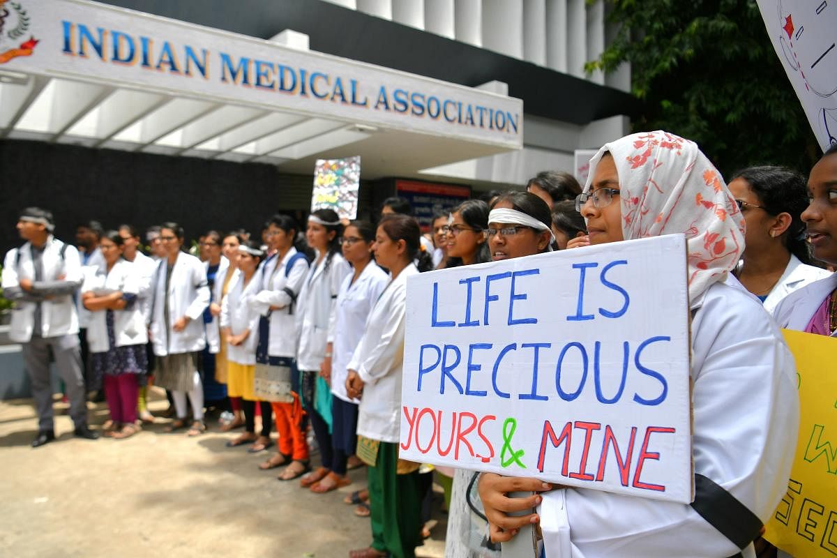 Indian medical students and doctors who are members of the Indian Medical Association (IMA) hold placards during a nationwide strike in Bangalore on June 17, 2018. - Tens of thousands of Indian doctors went on strike on June 17 calling for more protection against violence by patients and their families, as parliament met for the first time since national elections. AFP