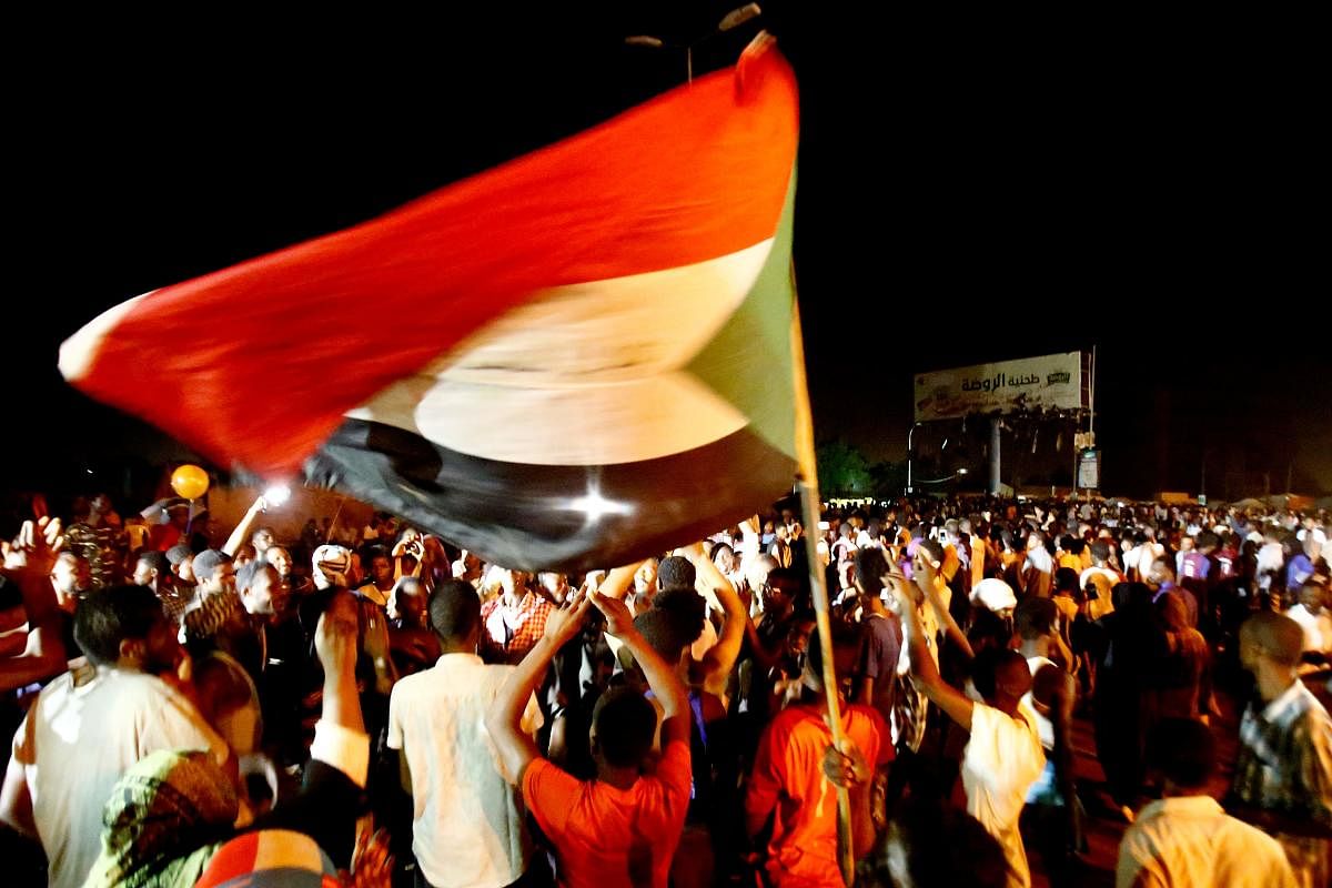 Sudanese wave flags and chant slogans as they gather during a demonstration outside the army headquarters in Khartoum. (Photo AFP)