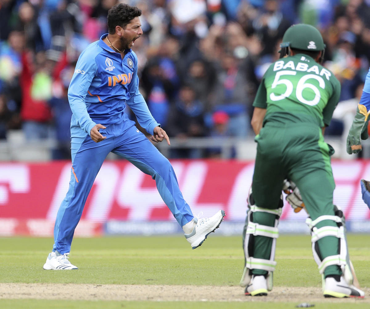 India's Kuldeep Yadav, left, celebrates the dismissal of Pakistan's Babar Azam, right, during the Cricket World Cup match between India and Pakistan at Old Trafford in Manchester, England, Sunday, June 16, 2019. (AP/PTI Photo)