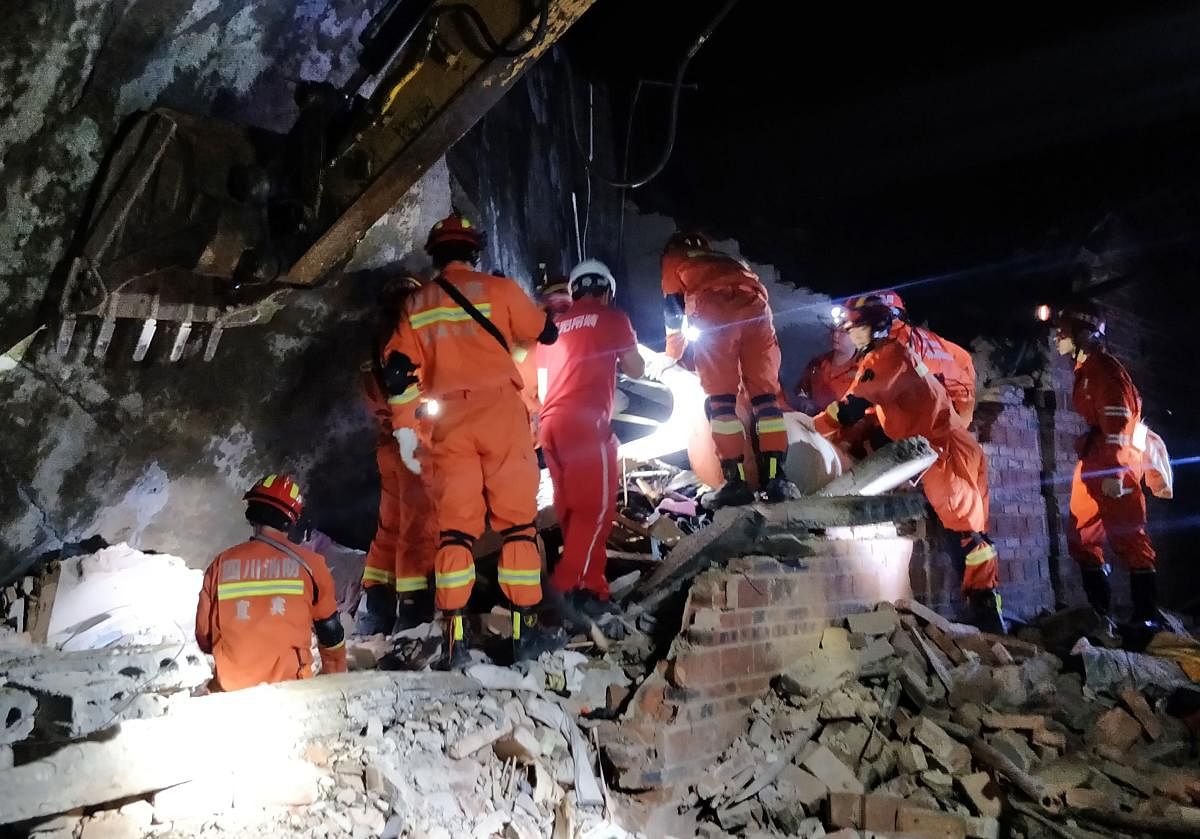 Rescuers search for earthquake survivors in the rubble of a building in Yibin, in China's southwest Sichuan province early on June 18, 2019. (AFP)
