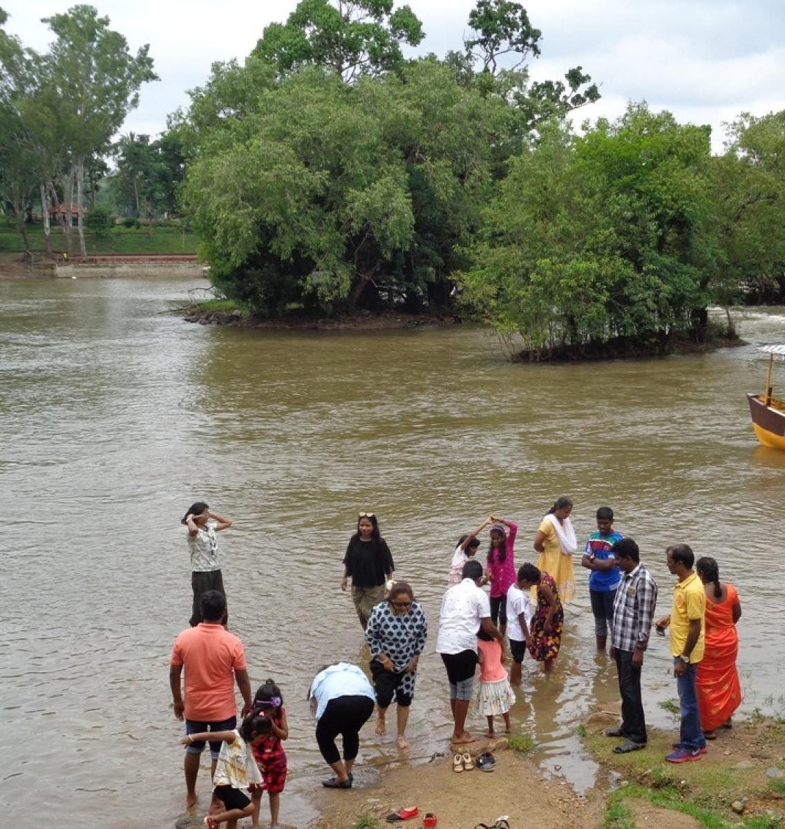 Tourists return from the banks of River Cauvery, as there is no boat to ferry them to Dubare elephant camp.