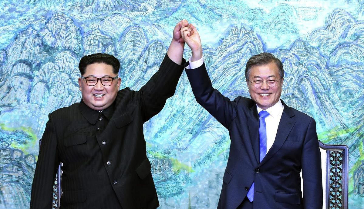North Korean leader Kim Jong Un, left, and South Korean President Moon Jae-in raise their hands after signing a joint statement at the border village of Panmunjom in the Demilitarized Zone, South Korea, Friday, April 27, 2018. AP/PTI Photo