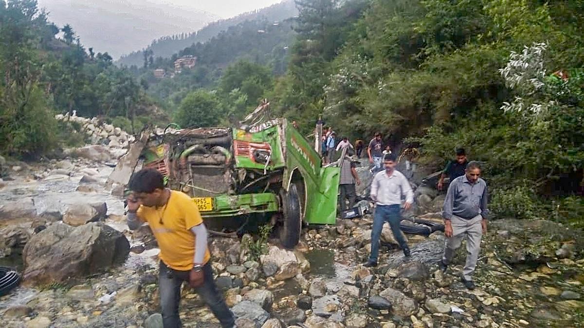 Mangled remains of a private bus after it fell into a 500-ft deep gorge, near Kullu, Thursday. PTI photo