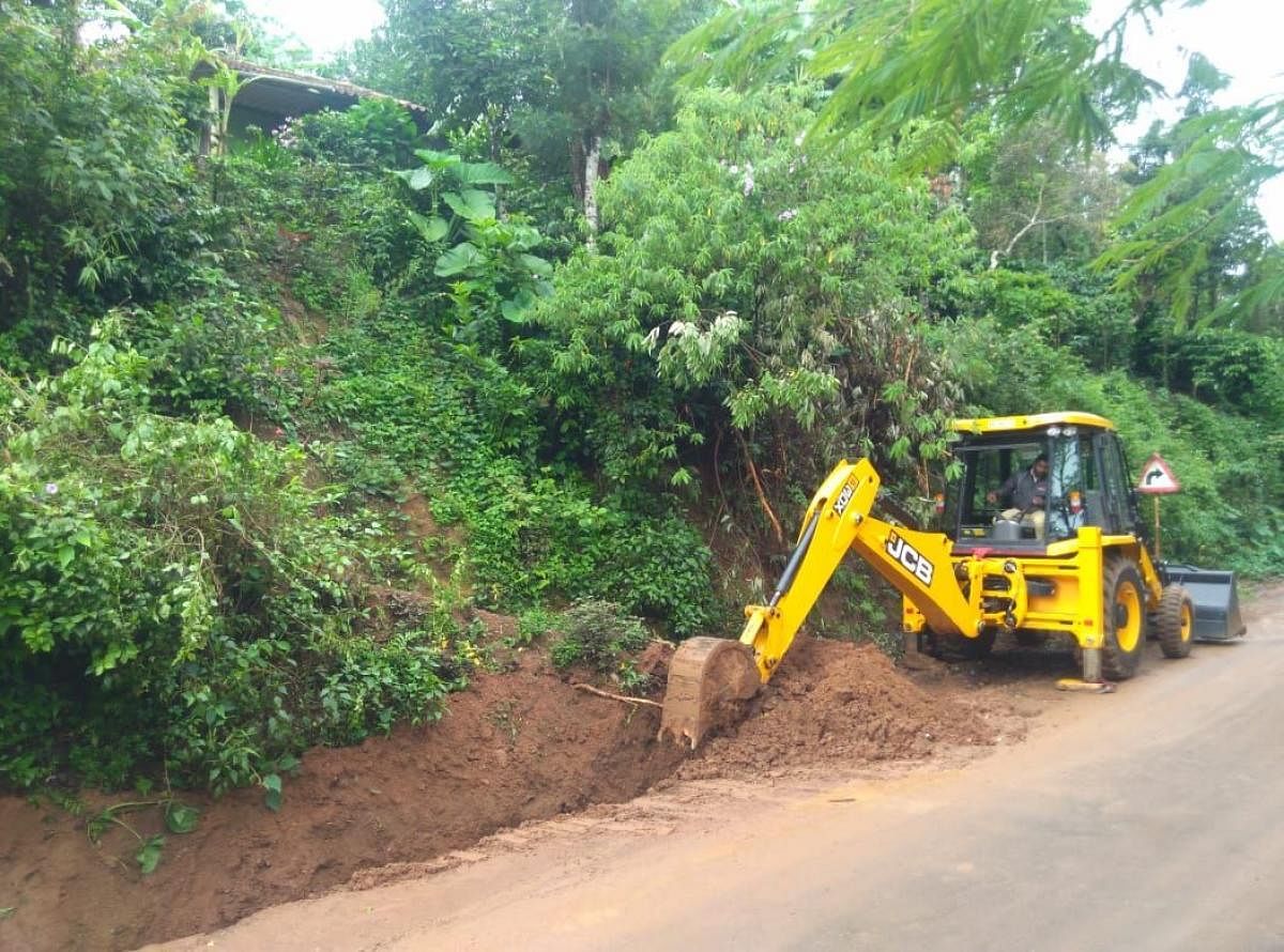 The Kattalekadu Road in Madikeri is being dug using an excavator.