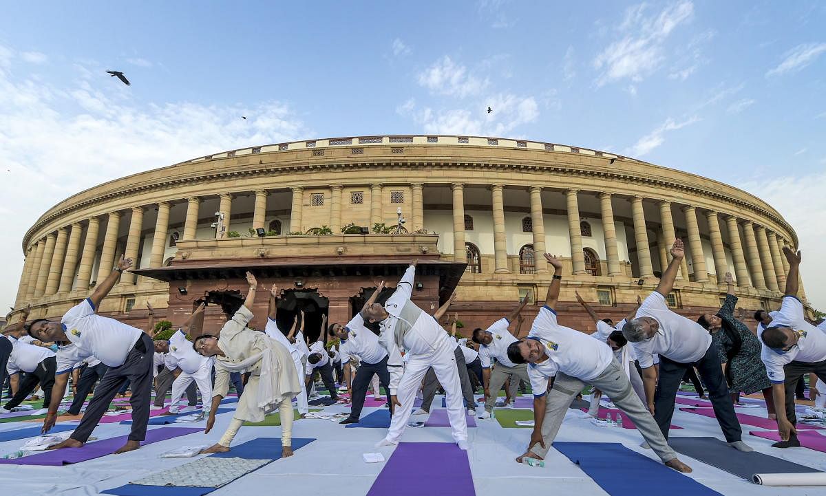 Lok Sabha Speaker Om Birla, Parliamentary Affairs Minister Prahlad Joshi, BJP General Secretary Bhupender Yadav along with other MP's and officials perform Yoga during the 5th International Day of Yoga at Parliament, in New Delhi, Friday, June 21, 2019. (