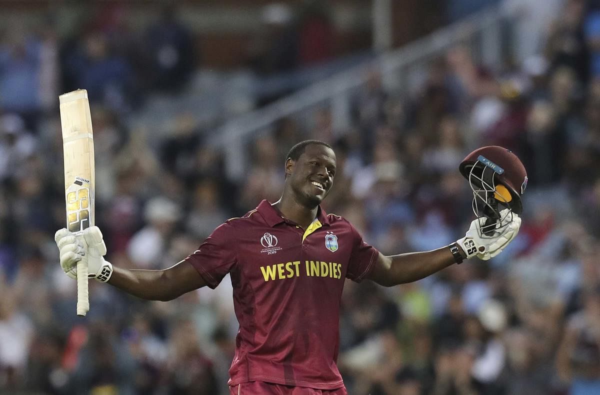West Indies' Carlos Brathwaite celebrates after scoring a century during the Cricket World Cup match between New Zealand and West Indies at Old Trafford in Manchester. (AP/PTI Photo)
