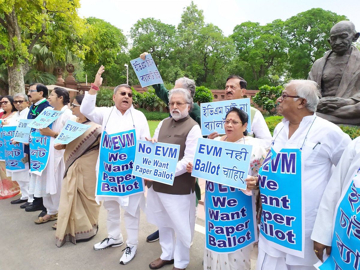 All India Trinamool Congress (TMC) MPs stage protest in front of Mahatma Gandhi statue at the Parliament with placards that read 'No EVM, We want paper ballot'. DH Photo. 