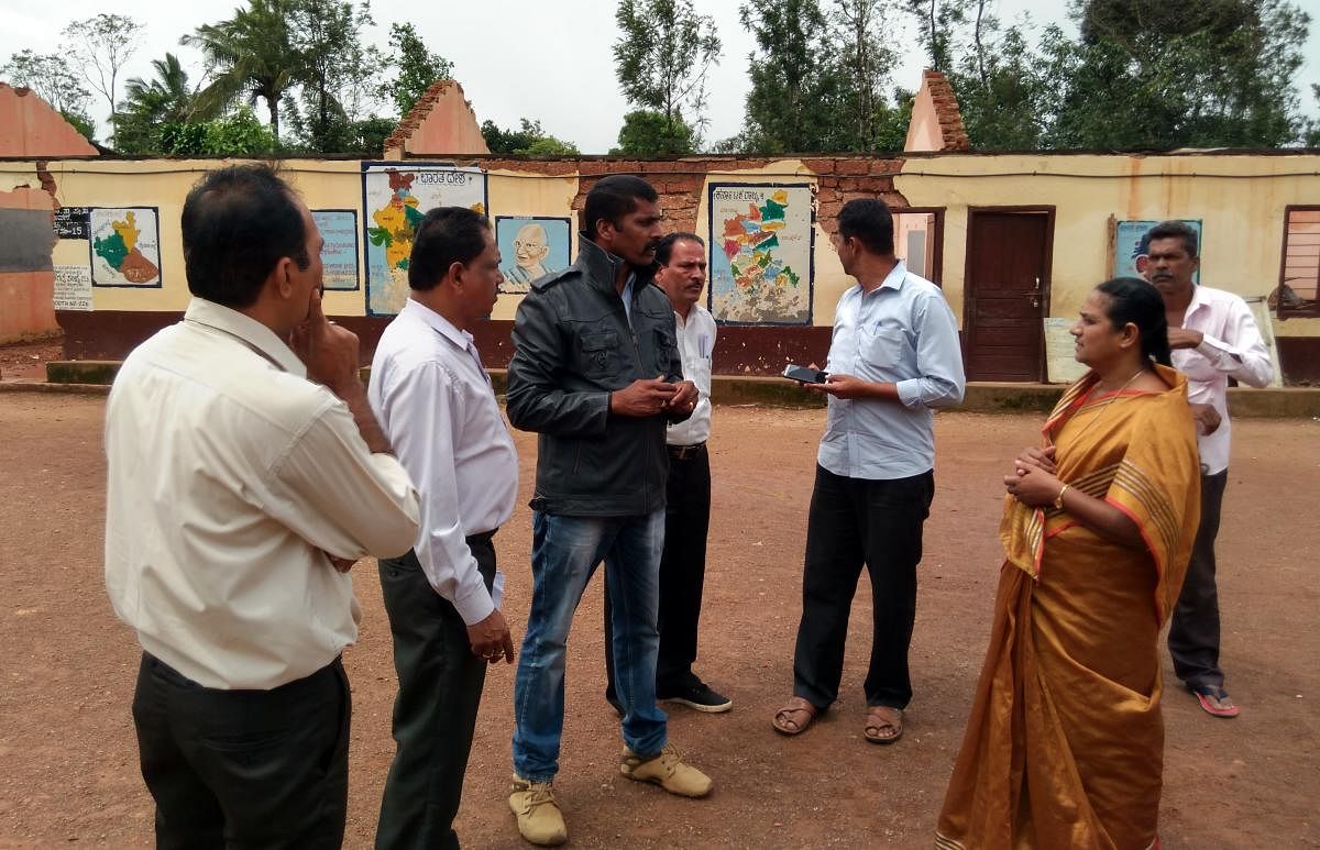 Taluk Panchayat member Appu Ravindra and PWD engineer Channakeshava visit the Government Model Primary School in Closeburn, Kattalekadu, on Monday.