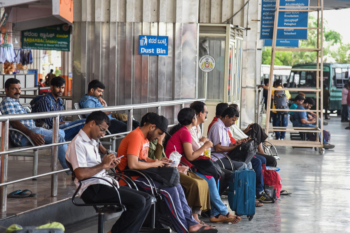 Passengers wait for Kerala buses at Satellite Bus stand, Mysuru Road, in Bengaluru on Monday. DH Photo/S K Dinesh