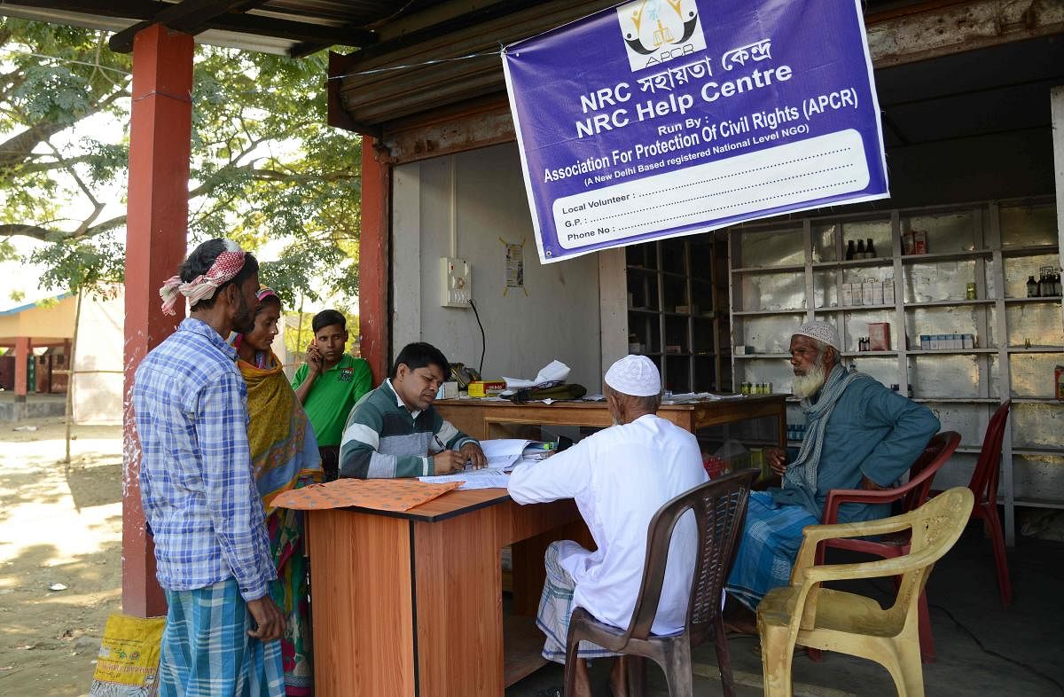 In this photo taken on December 8, 2018, villagers gather to check their documents at a National Register of Citizens (NRC) help centre for people whose names were not featured in the final draft of the NRC at Hatisola village in Kamrup district in India'