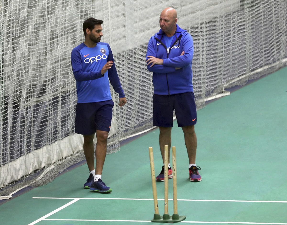 Bhuvneshwar Kumar, left, speaks to team physiotherapist Patrick Farhar during an indoor training session ahead of their Cricket World Cup match against West Indies at Old Trafford. Photo credit: PTI