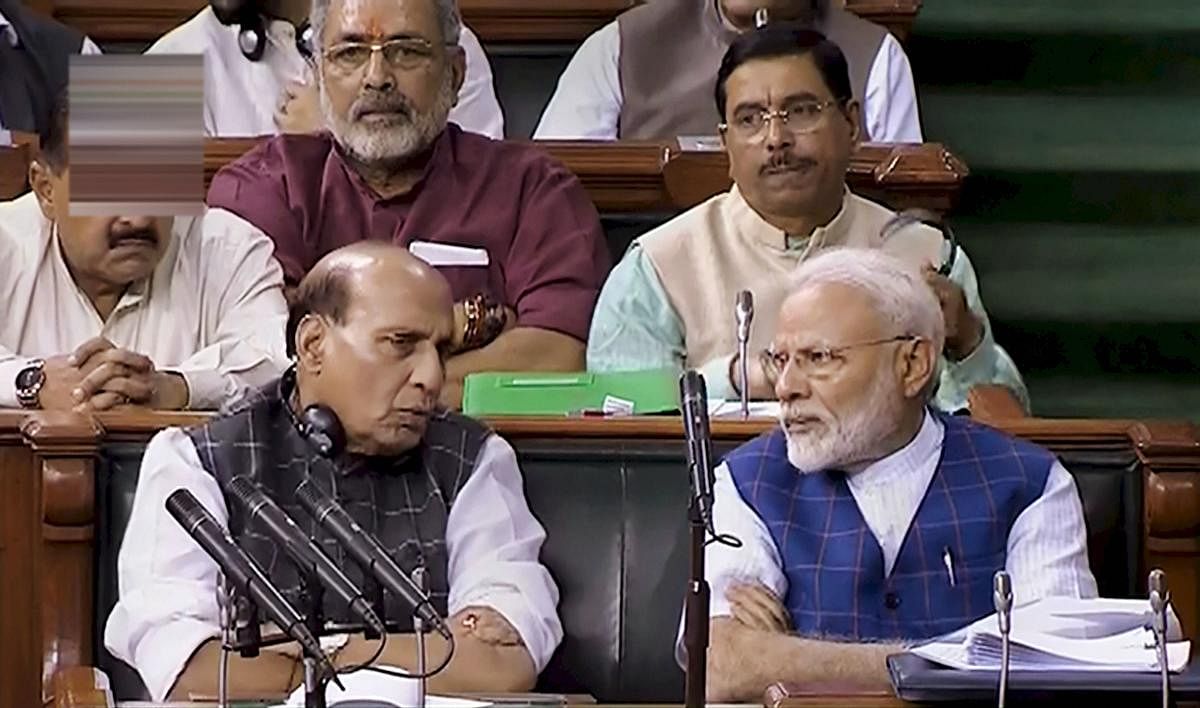 New Delhi: Prime Minister Narendra Modi speaks with Defence Minister Rajnath Singh in the Lok Sabha, at Parliament in New Delhi. (PTI Photo)