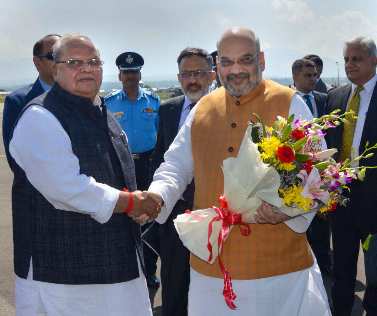 Srinagar: Union Home Minister Amit Shah being received by Jammu and Kashmir Governor Satya Pal Malik on his arrival at the airport in Srinagar. (PTI Photo)