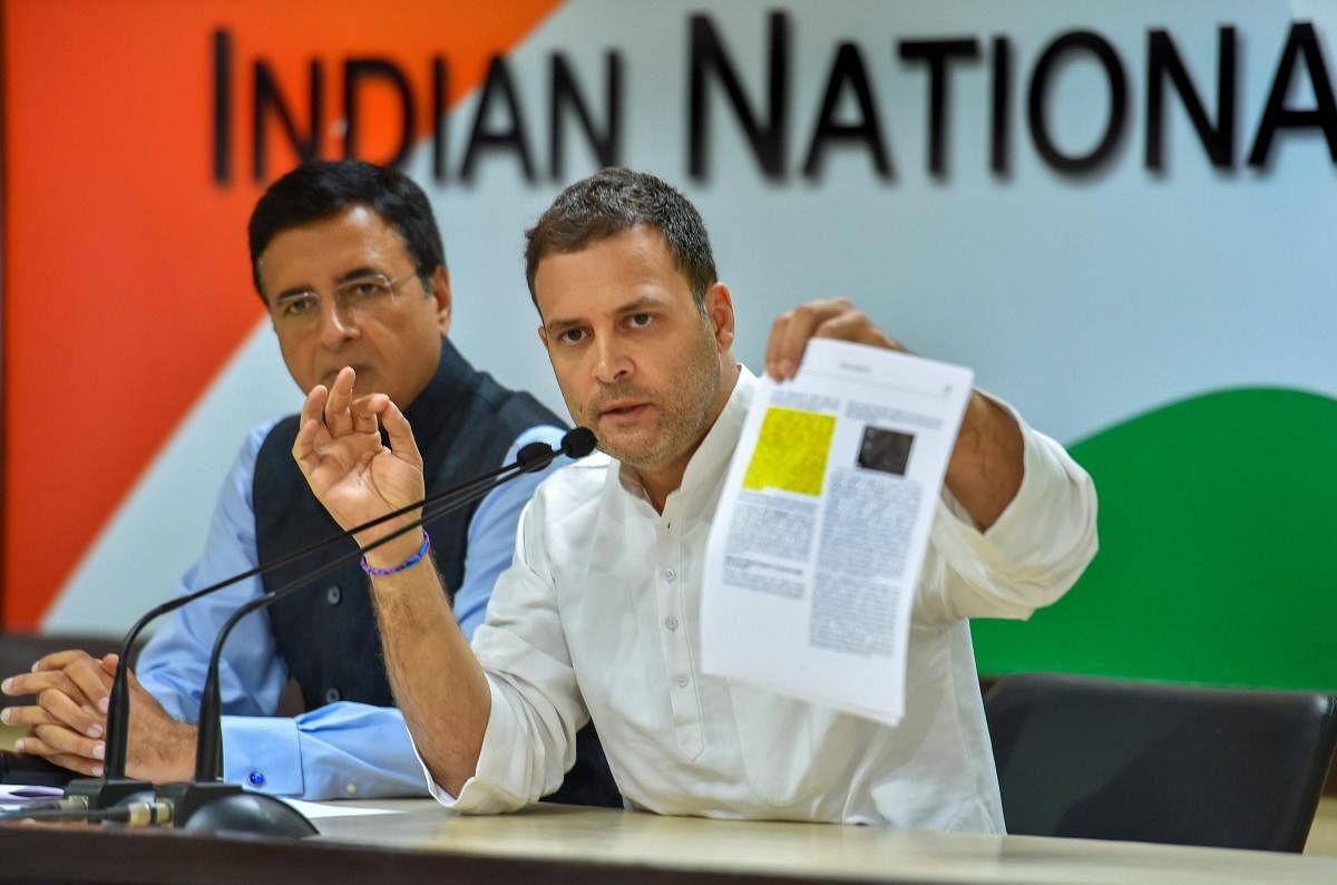 Congress president Rahul Gandhi speaks during a press conference as AICC chief spokesperson Randeep Singh Surjewala looks on, in New Delhi on Thursday. (PTI Photo)