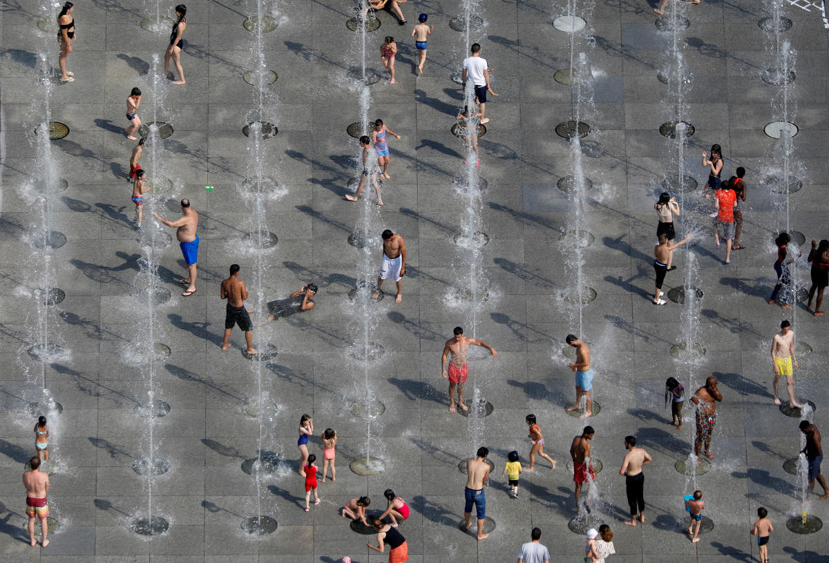 People cool off in the fountains at the Andre Citroen park in Paris as a heatwave hit much of the country. (Reuters Photo)