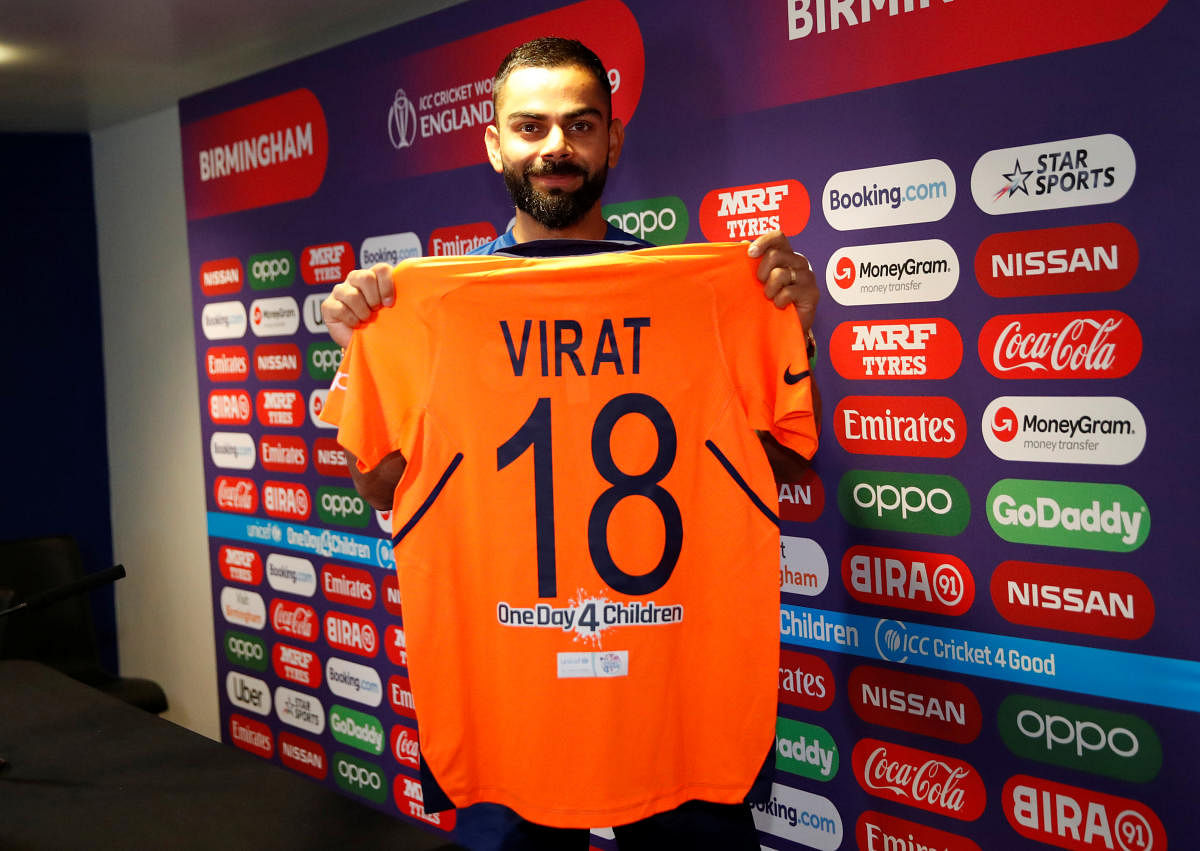 NICE AND BRIGHT: Indian skipper Virat Kohli shows the new orange jersey on Saturday. Reuters