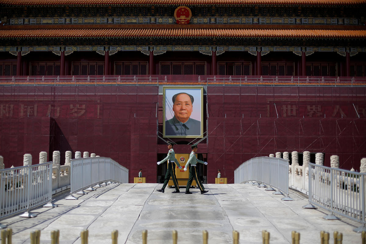 Paramilitary officers change guard in front of the portrait of the late Chinese chairman Mao Zedong in Tiananmen Square in Beijing, China May 7, 2019. REUTERS/Thomas Peter/File Photo