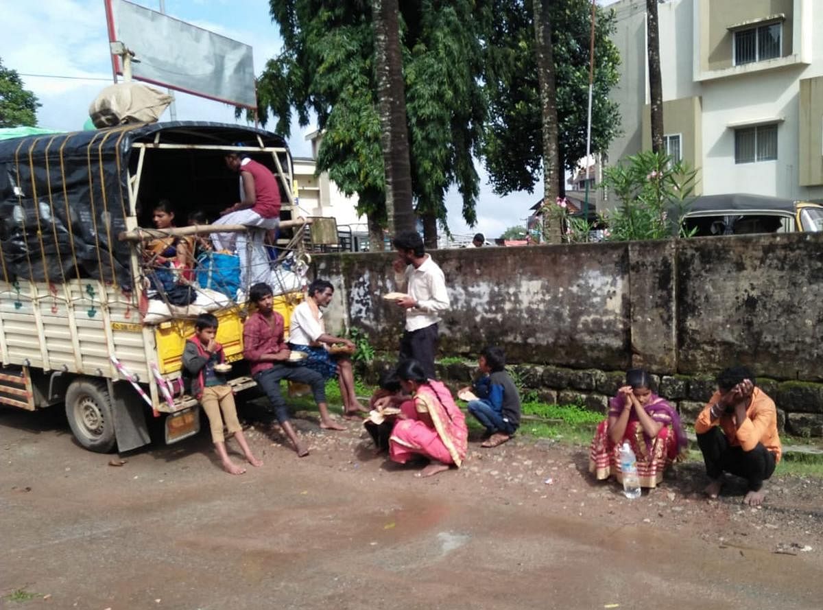 Migrant labourers wait in front of Mudigere police station.