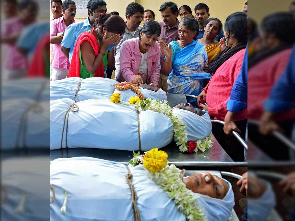 Relatives of Bharathi, Ramesh and Jagadish, who were killed in a tree fall on Friday night, break down at the Victoria Hospital mortuary. DH Photo