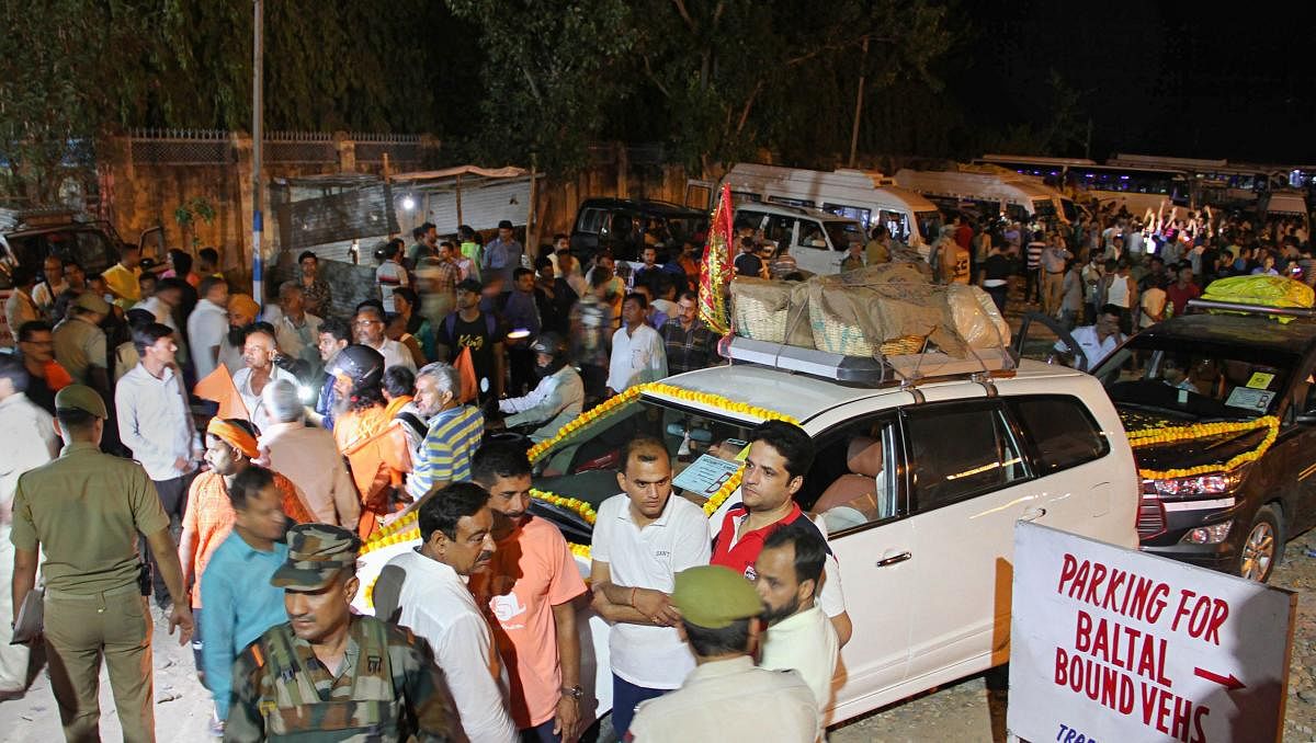 Security personnel stand guard as vehicles carrying the first batch of Amarnath pilgrims leave for yatra from Jammu. (PTI Photo)