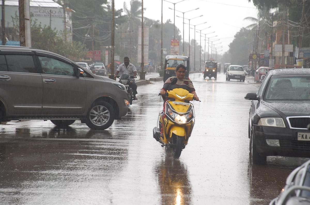 A motocyclist braves rain in Gadag on Sunday. DH Photo