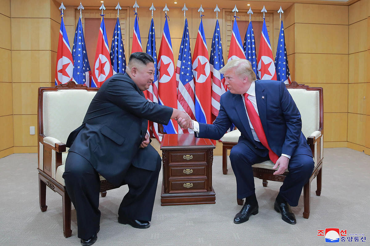 North Korean leader Kim Jong Un, left, and U.S. President Donald Trump shake hands inside the Freedom House on the southern side of Panmunjom, South Korea. (PTI Photo)