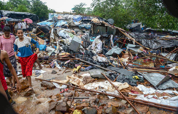 Debris seen after a portion of a compound wall collapsed on shanties adjacent to it due to heavy rainfall. (PTI Photo)