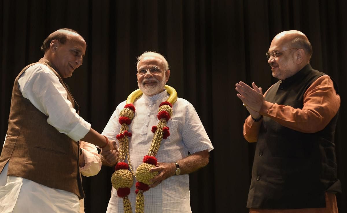 Prime Minister Narendra Modi is garlanded by Bharatiya Janata Party (BJP) senior leaders Amit Shah and Rajnath Singh during the BJP parliamentary party meeting, in New Delhi, Tuesday, July 02, 2019. (PTI Photo)