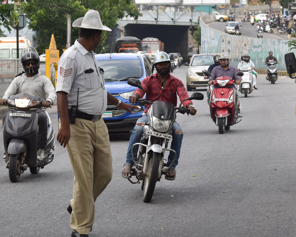Traffic police stop vehicles for traffic rules violation on Outer Ring road near Nagarabhavi in Bengaluru. DH Photo/Janardhan B K