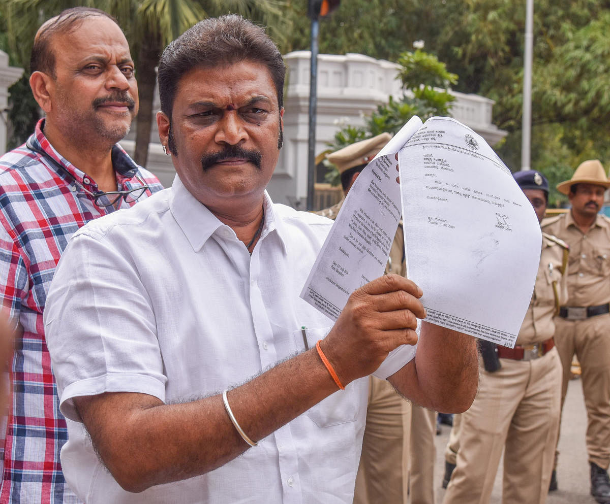 Anand Singh, MLA, Vijayanagar, Ballari district, shows a copy of his resignation letter after after submitting it to Governor at Raj Bhavan in Bengaluru on Monday. DH Photo/S K Dinesh