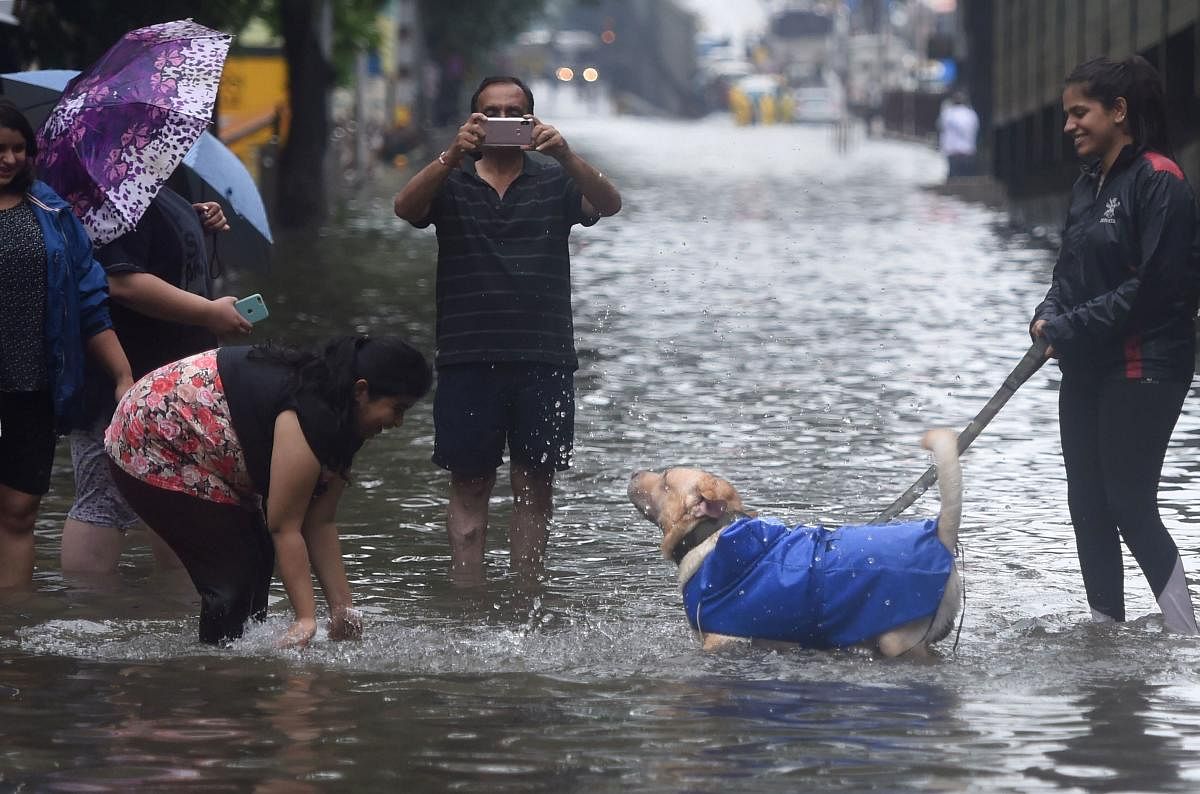 Heavy rains in Mumbai and adjoining areas on Tuesday flooded its roads and crippled its rail lines, but the famed "we'll get through this just fine" spirit of the metropolis, as always, remained afloat. (PTI Photo)