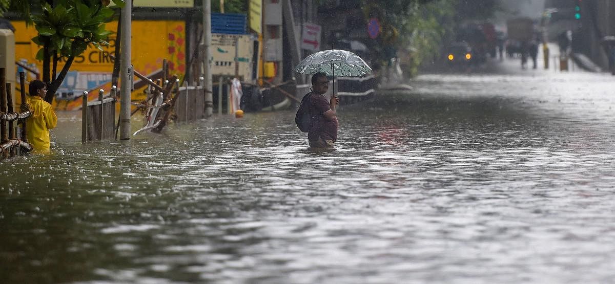 A man wades through a waterlogged street during heavy monsoon rain at Sion in Mumbai on Tuesday. PTI photo