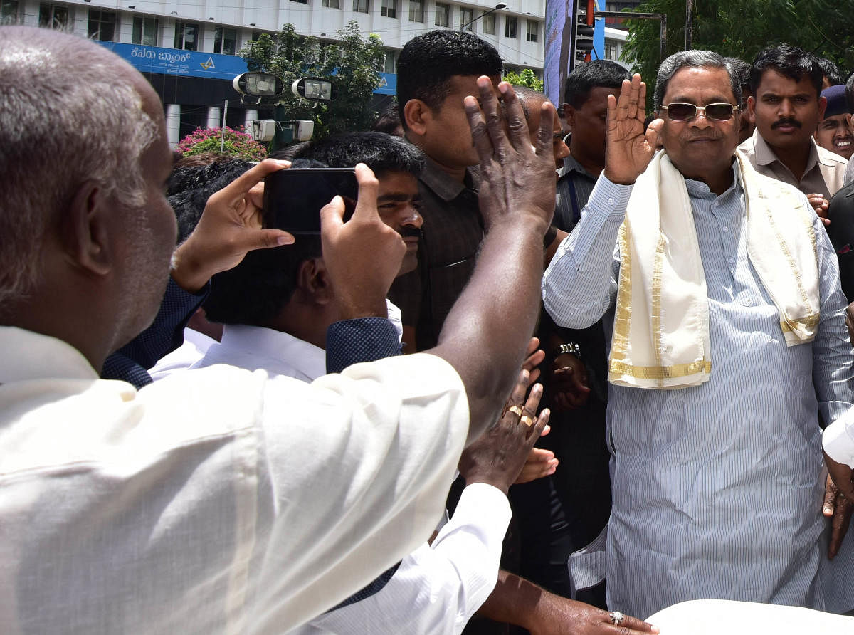 Former chief minister Siddaramaiah waves at his supporters during a programme organised by Karnataka Scheduled Castes and Scheduled Tribes Contractors' Association in Bengaluru on Tuesday. DH Photo