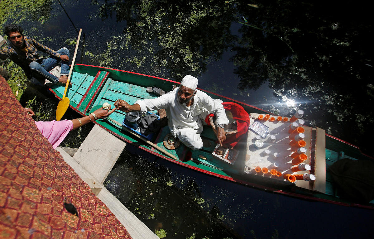 A vendor sitting on a boat sells ice cream at Dal Lake in Srinagar on June 27, 2019. REUTERS