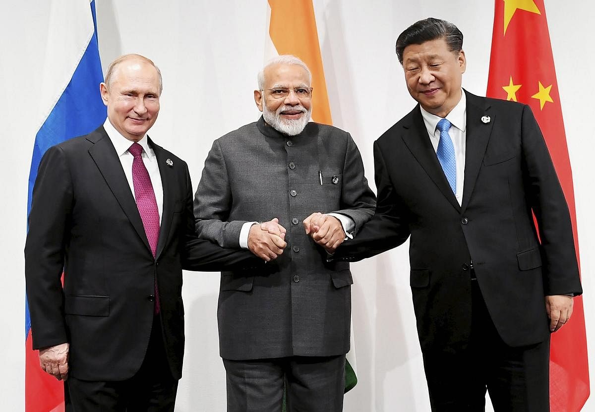 Prime Minister Narendra Modi with Russian President Vladimir Putin (L) and Chinese President Xi Jinping at an informal meeting between Russia, India and China (RIC), on the sidelines of the G-20 Summit, in Osaka, Japan. PTI