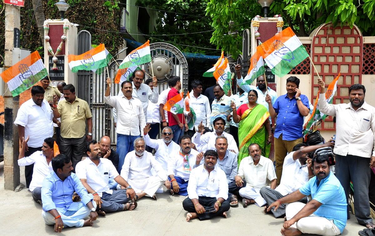 Congress workers, joined by DCC office-bearers, stage a dharna in front of Vijayanagara MLA Anand Singh's residence in Hosapete on Wednesday.