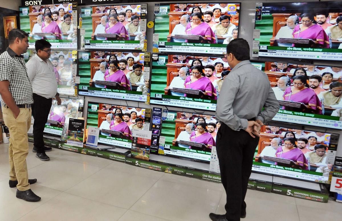 People watch Finance Minister Nirmala Sitharaman tabling the Union Budget 2019-20, on TV sets at a showroom in Kolkata. (PTI Photo)
