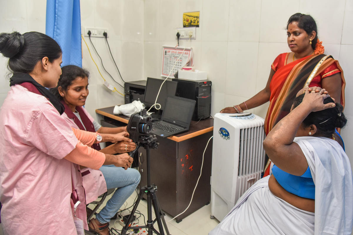 Medical lab technicians scan a woman during a breast cancer screening on H Siddaiah Road on Friday. DH PHOTO/S K DINESH