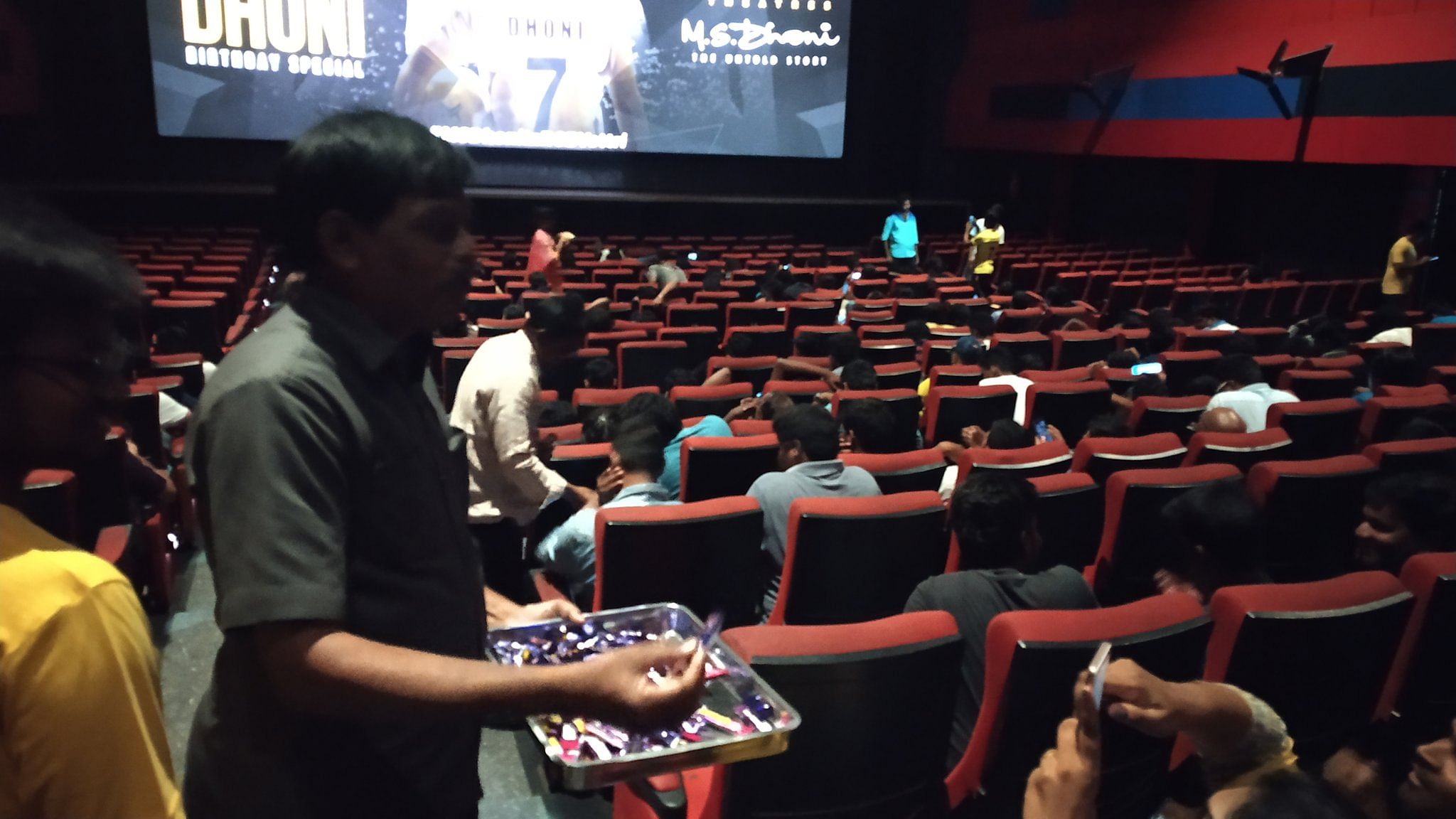 Fans distributing chocolates during the screening of MS Dhoni biopic. (Image courtesy Twitter)