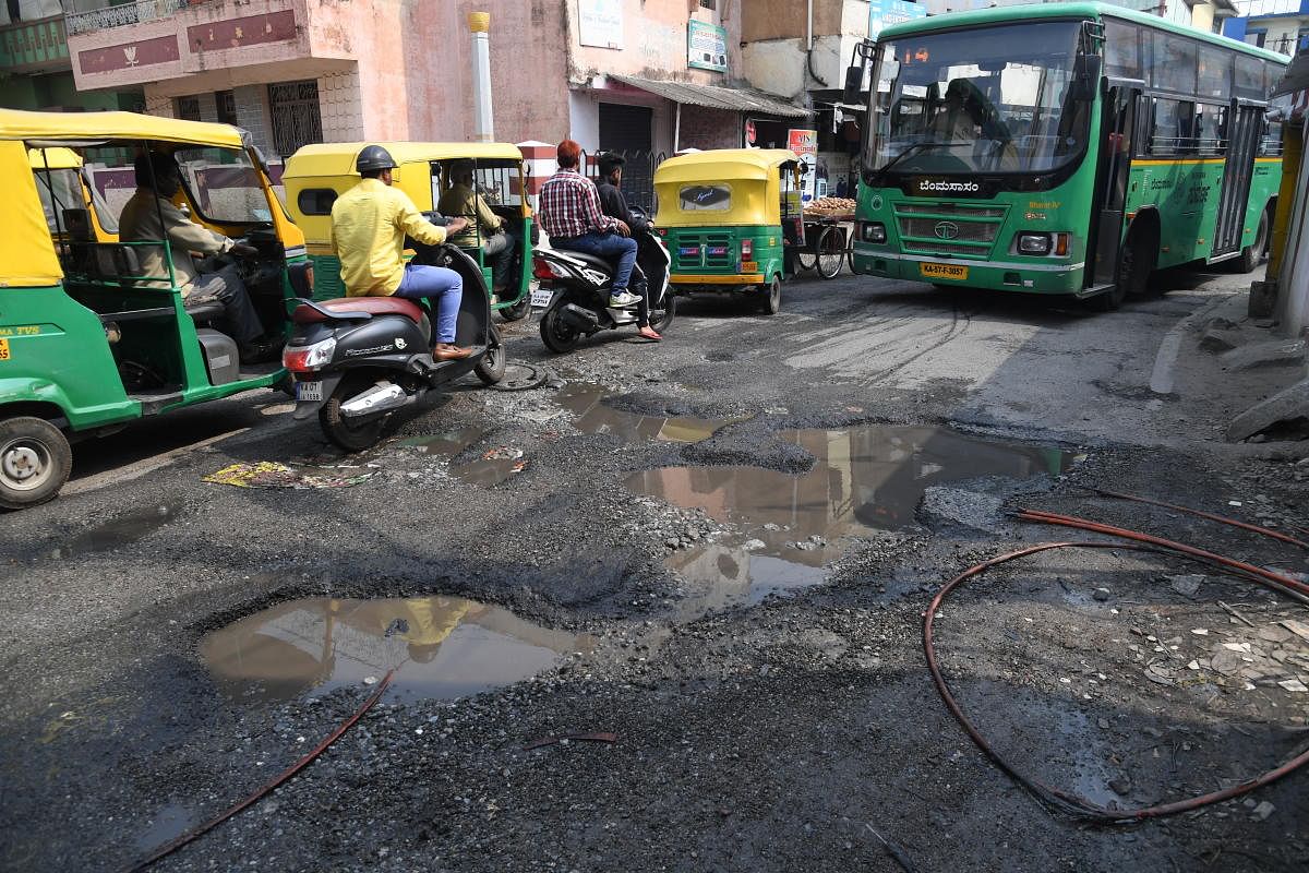Motorists are struggle to drive on a Big Pothole on the Tannery road in Bengaluru on Tuesday. Photo/ B H Shivakumar
