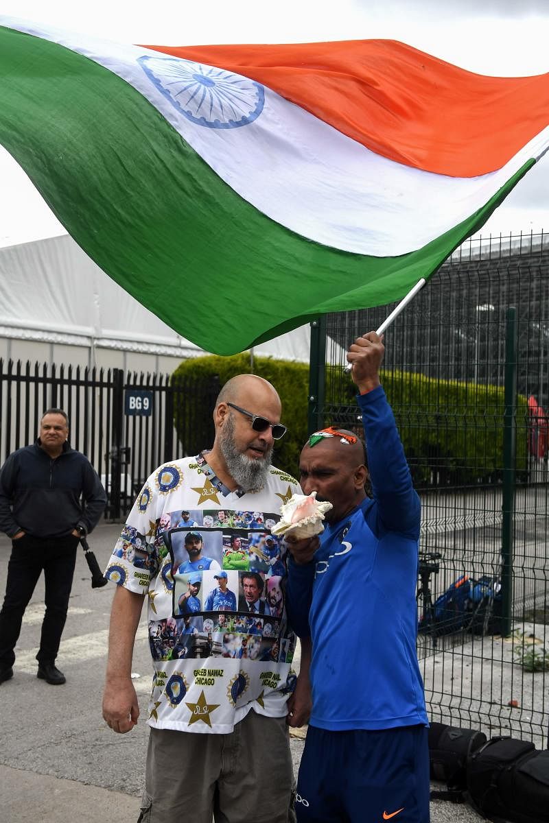 Indian cricket fan Sudir Gautam (right) and Pakistani fan Mohammad Bashir greet each other at Old Trafford on Saturday. AFP