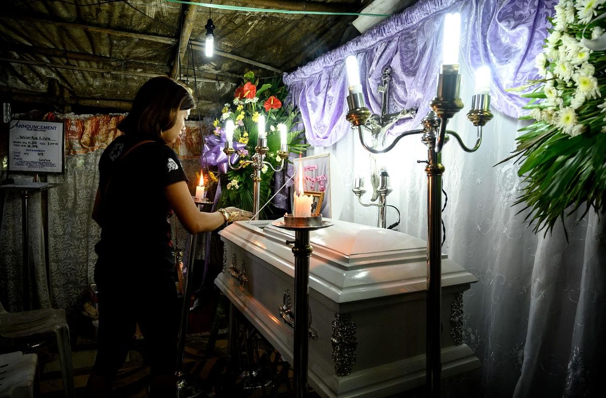The mother views the coffin of her 3-year-old baby Kateleen Myca Ulpina, killed during a sting operation conducted by the police, is seen during her wake in Rodriguez, Rizal, east of Manila. (AFP Photo)