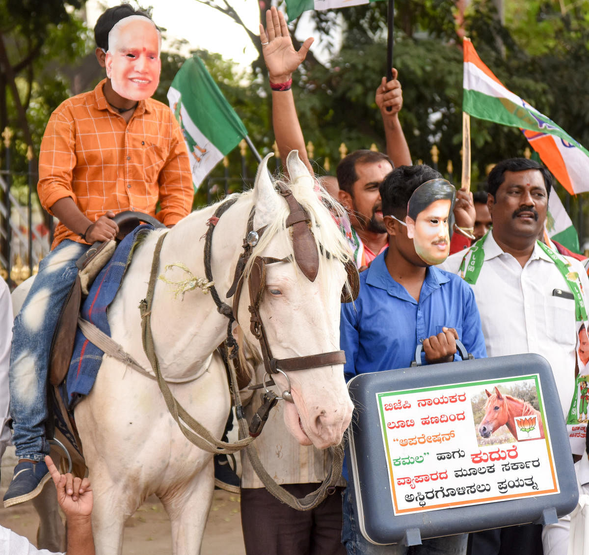 Congress members tage a protest accusing the BJP of horse-trading for capturing power in the state, in Bengaluru on Monday. DH Photo