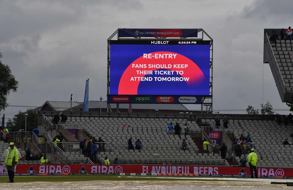 A big screen board gives spectators information after the suspension of play for the day in the 2019 Cricket World Cup first semi-final between India and New Zealand at Old Trafford in Manchester, northwest England, on July 9, 2019. (AFP)