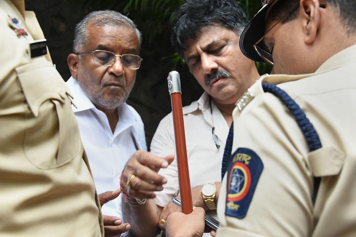 Karnataka Ministers D Shivkumar &amp; G T Devegowda interact with the police personnel at Hotel Renaissance, where the 10 rebel MLAs are staying, in Mumbai, Wednesday, July 10, 2019. (PTI Photo)