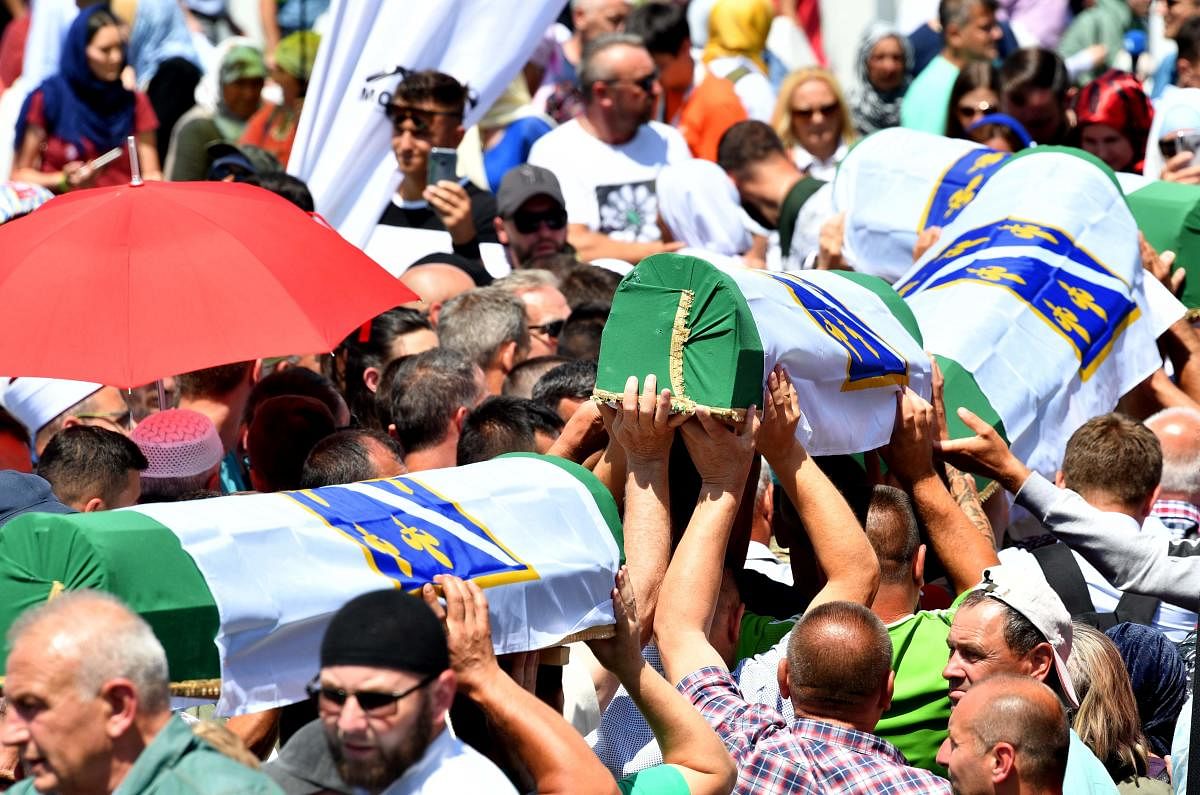 Bosnian Muslims carry caskets of the 33 newly identified bodies of the 1995 Srebrenica massacre before their inhumation at the Potocari memorial cemetery near the Eastern-Bosnian town of Srebrenica (AFP Photo)