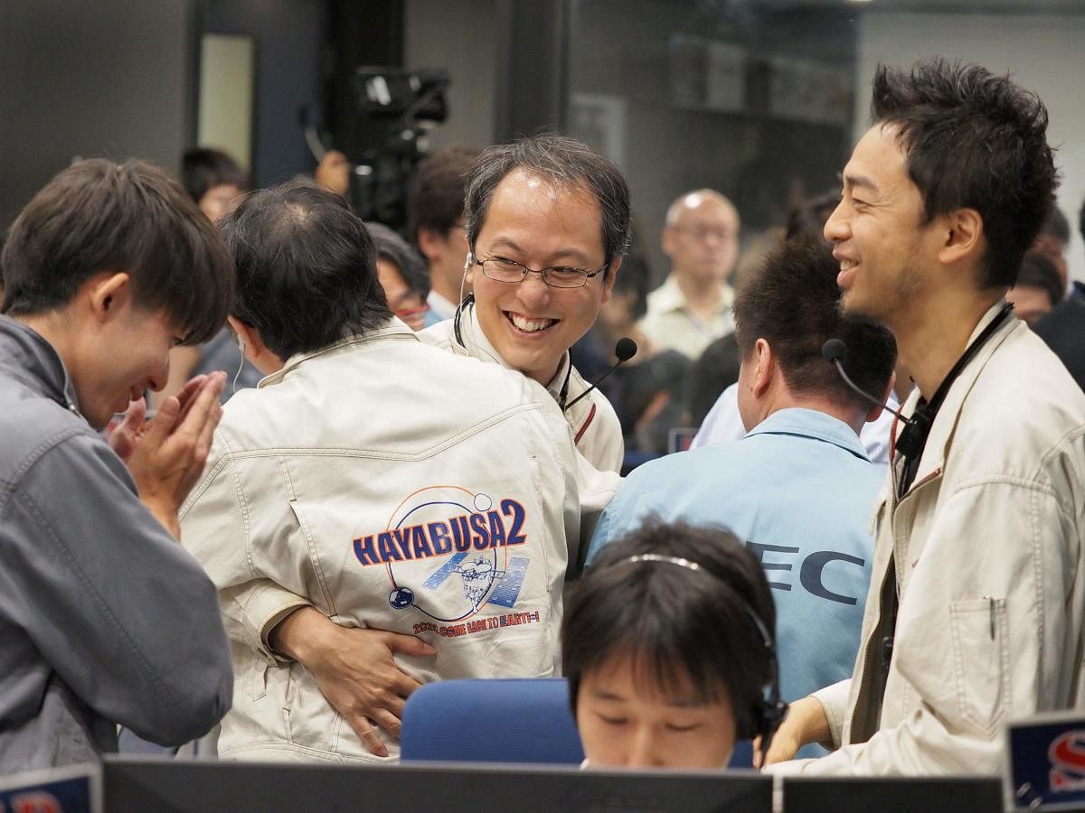 This handout photograph taken and released by the Institute of Space and Astronautical Science (ISAS) of Japan Aerospace Exploration Agency (JAXA) on July 11, 2019 shows researchers and employees celebrating after receiving confirmation of Hayabusa2's touchdown on the asteroid Ryugu. AFP