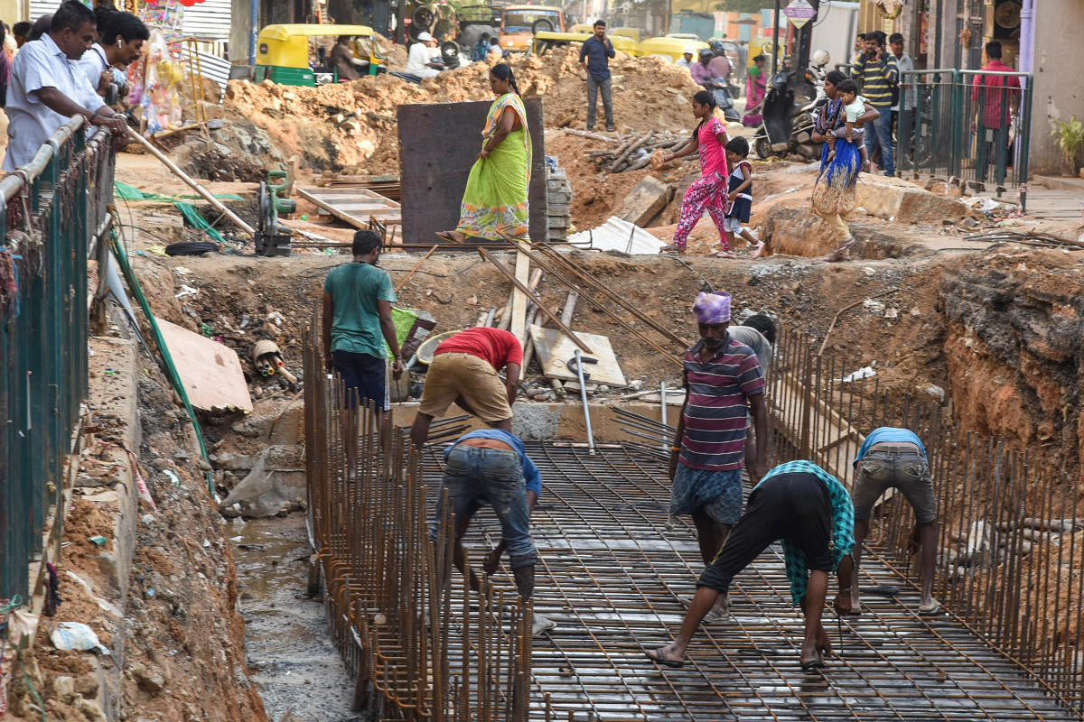 People suffering to cross the road, due to Tender SURE work is not eat start, BWSSB laying underground pipe and Rajakaluve (Storm water drain) work is going slow, in Cottonpet main road, Bengaluru on Friday. Photo by S K Dinesh