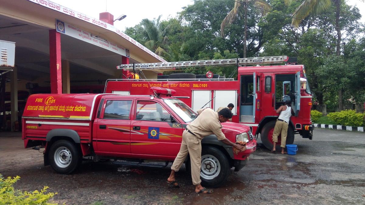 Firefighters involved in their routine work, including cleaning the vehicles and equipment checking, at District Fire Station in Udupi.