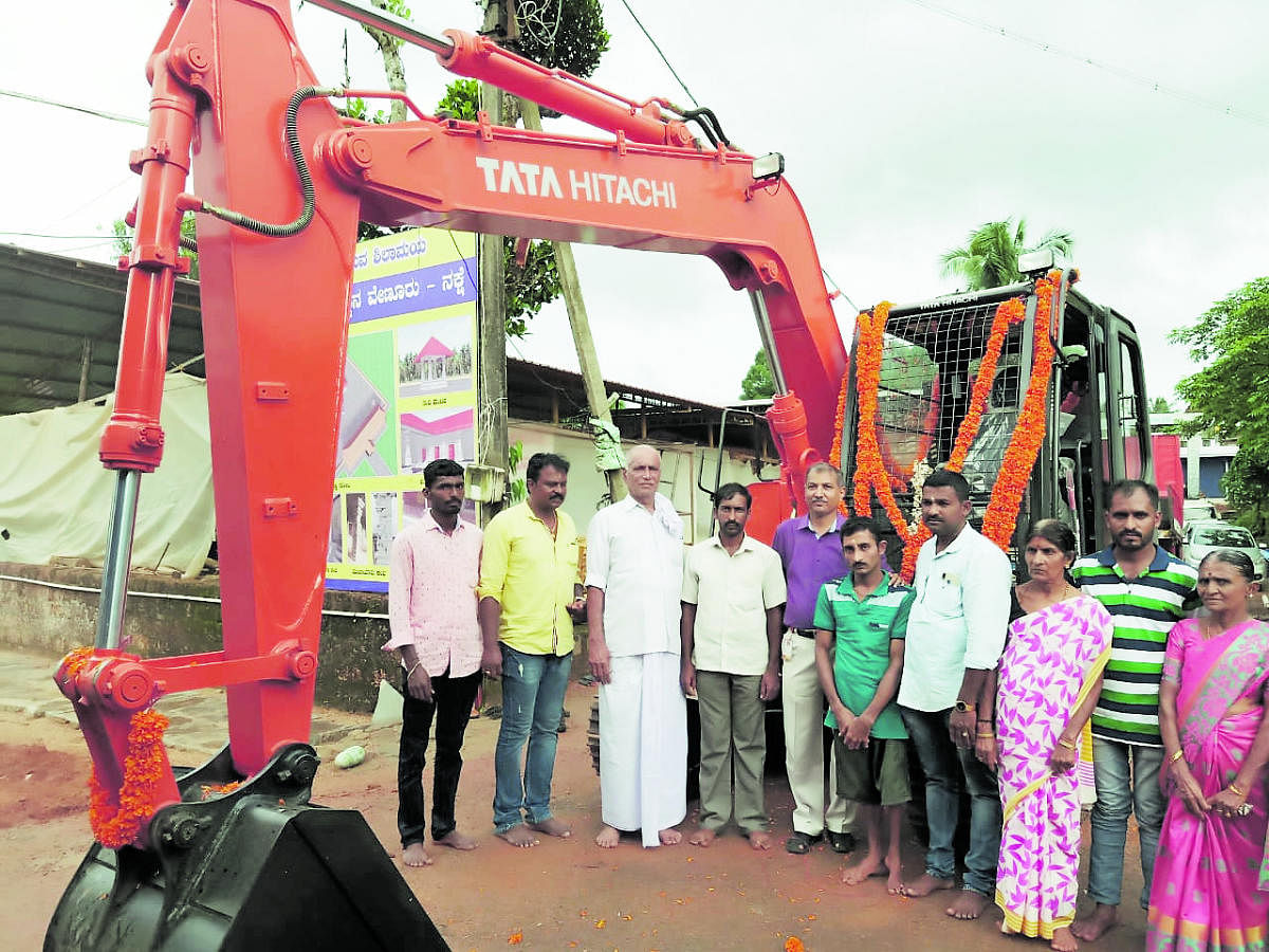 Ranjeeth, with his brother Pradeep, an endosulfan victim, and members of the family, is seen with the new excavator that was purchased with help from the Syndicate Bank’s Venur branch in Andinje.